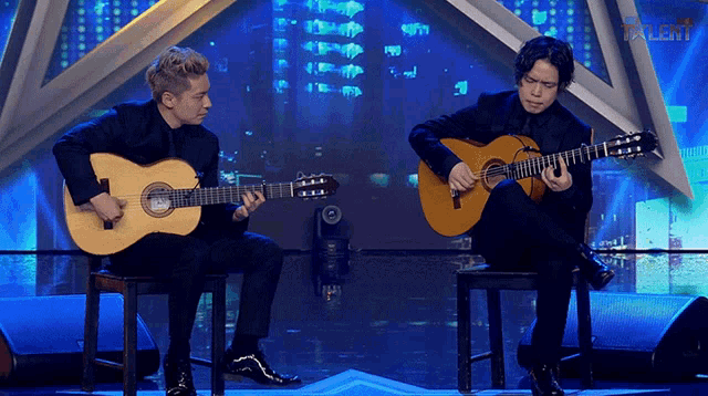two men playing guitars on a stage with the word talent on the bottom