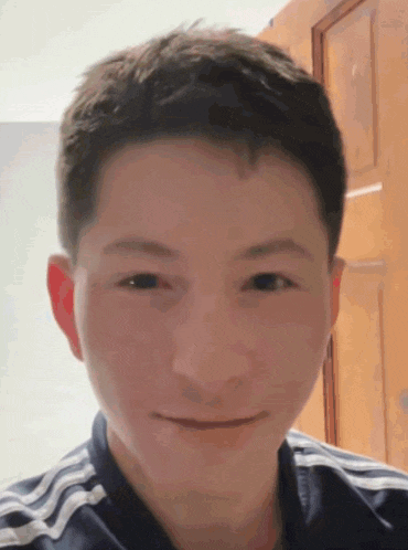 a close up of a person 's face with a striped shirt on