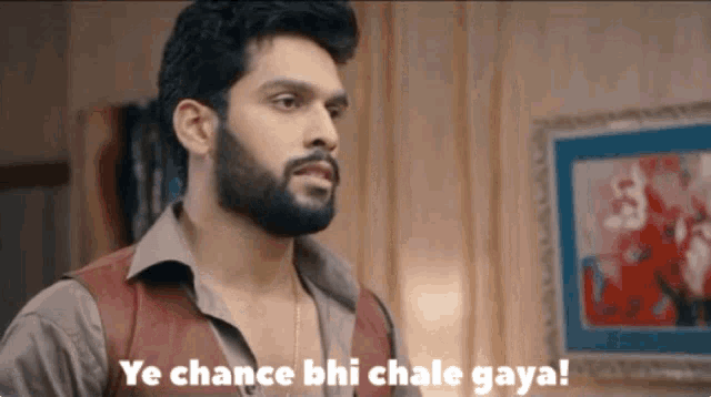 a man with a beard is standing in front of a framed picture and says ye chance bhi chale gaya