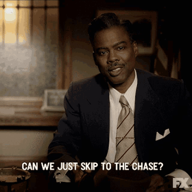 a man in a suit and tie is asking if we can just skip to the chase