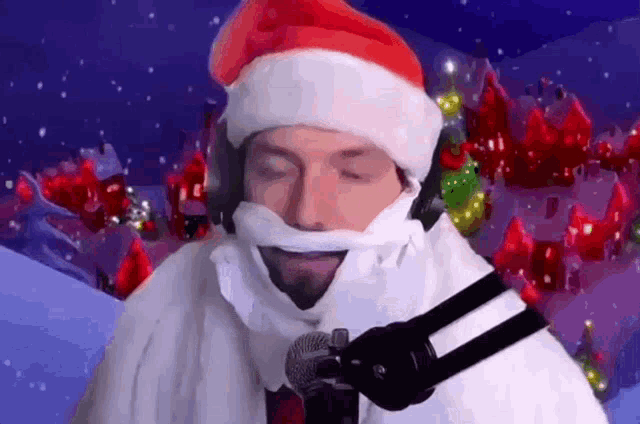 a man with a santa hat and beard is singing into a microphone ..