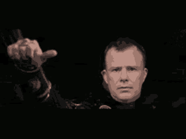 a man in a black jacket is giving a thumbs up