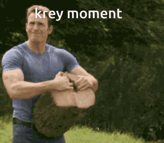 a man in a blue shirt is holding a large log with the words krey moment on the bottom