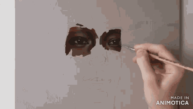 a person is painting a face with a brush and the words made in animatica are visible