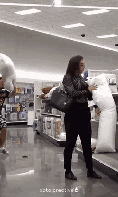 a woman is holding a pillow in a store with xpto creative written on the bottom