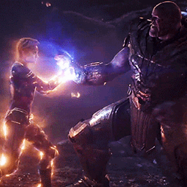 thanos and captain marvel are fighting in a dark room .