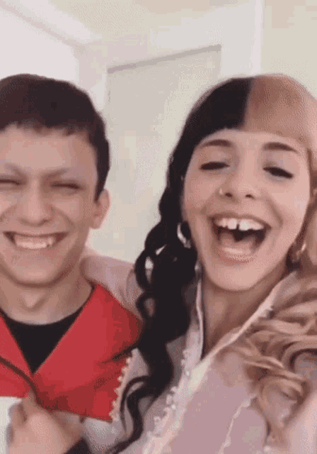 a man and a woman are smiling for the camera .