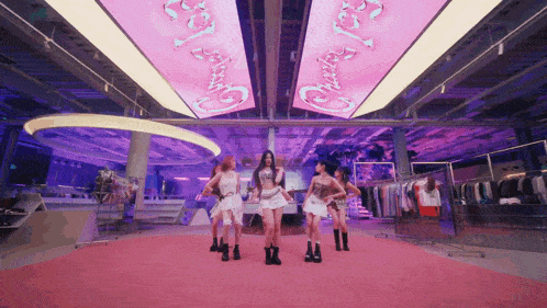 a group of women are dancing in a room with a neon sign that says " cherry "