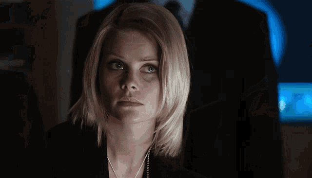 a woman with blonde hair is looking at something