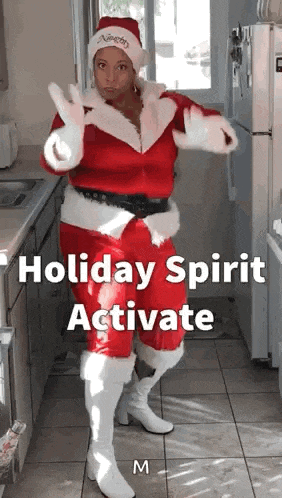 a woman in a santa suit is dancing in a kitchen with the caption holiday spirit activate