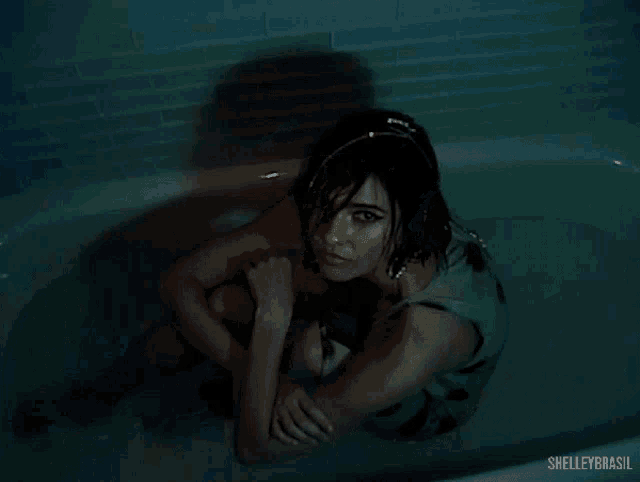 a woman is laying in a bathtub with the words shelley brasil written on the bottom