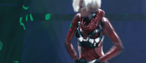 a woman in a red bodysuit is dancing in front of a blue background