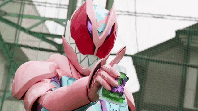 a person in a pink and purple costume is holding a green object