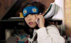a woman wearing a sleep mask is talking on her cell phone