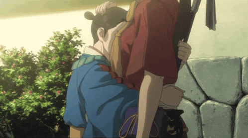 a man in a blue shirt is hugging a woman in a red top