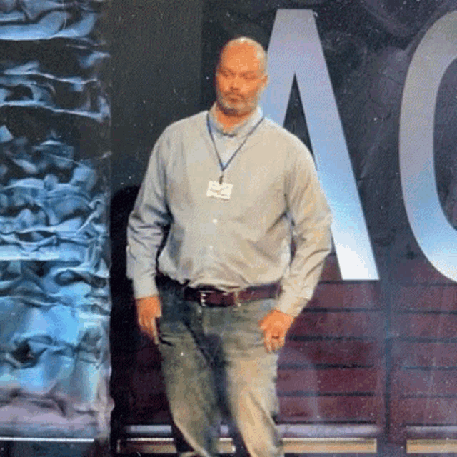 a man standing in front of a large letter a on a wall
