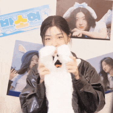 a girl holding a stuffed animal in front of a sign that says ' a '