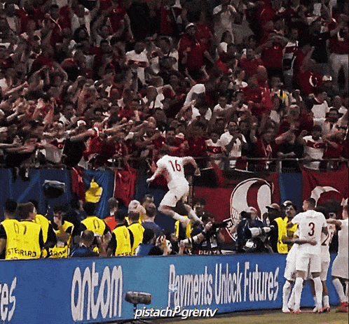 a soccer player with the number 16 on his jersey jumps in the air