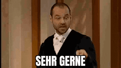 a man in a suit and tie is giving a speech and pointing at the camera with the words `` sehr gerne '' .