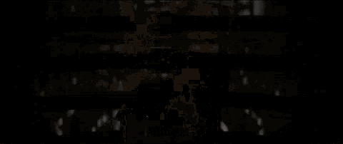 a person is looking through a sniper scope at a building in a dark room .