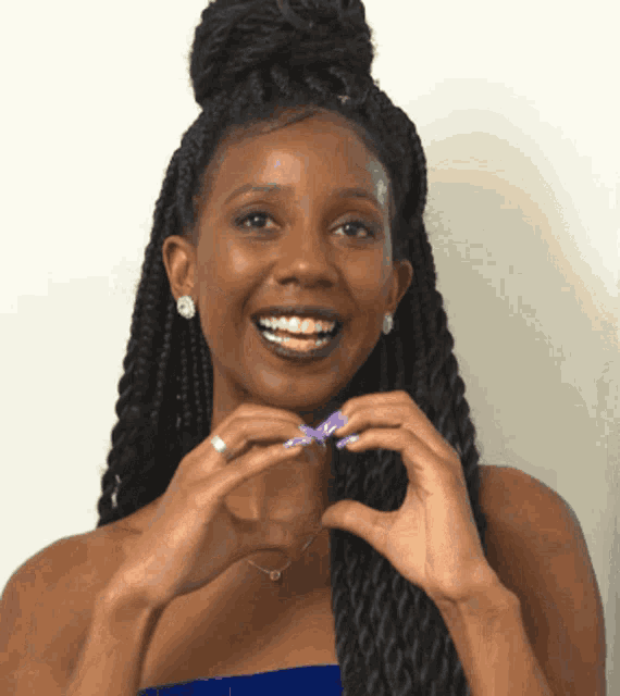 a woman with braces on her teeth is smiling and holding a purple object