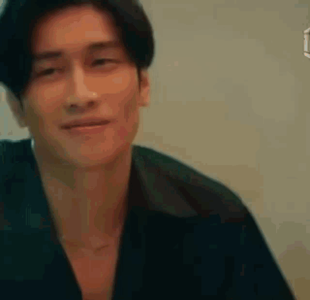 a close up of a man wearing a black shirt and looking at the camera .