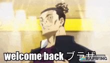 a man with a bun on his head is standing in front of a yellow wall and says welcome back .