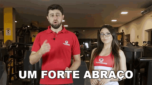 a man and a woman standing in a gym with the words um forte abraco