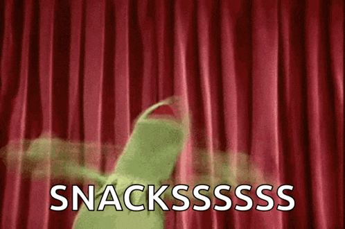 a kermit the frog is dancing in front of a red curtain with the words snacksssss written on it .