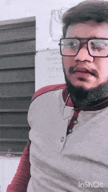 a man with glasses and a beard is standing in front of a sign that says ' inshot '