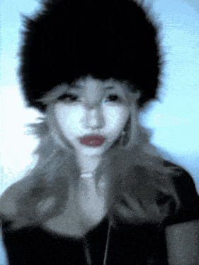 a blurry picture of a woman wearing a black fur hat