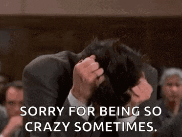a man in a suit and tie is holding his head in his hands and says `` sorry for being so crazy sometimes . ''