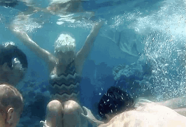 a woman in a bathing suit is swimming under water
