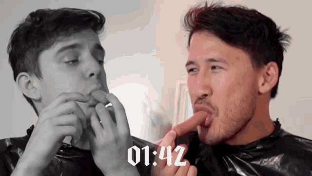 a man is eating a hot dog with the time 01:42 on the bottom
