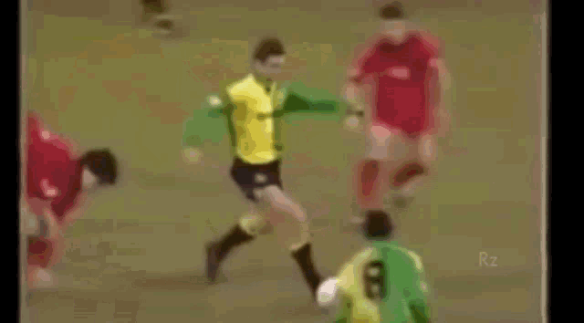 a group of soccer players are playing on a field . one of the players is wearing a yellow jersey .