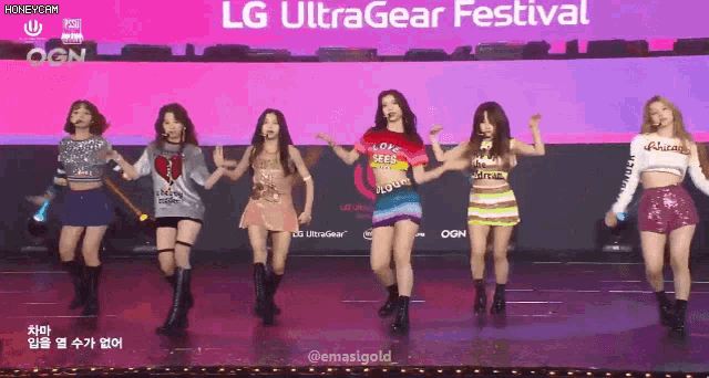 a group of girls are dancing in front of an lg ultragear festival sign