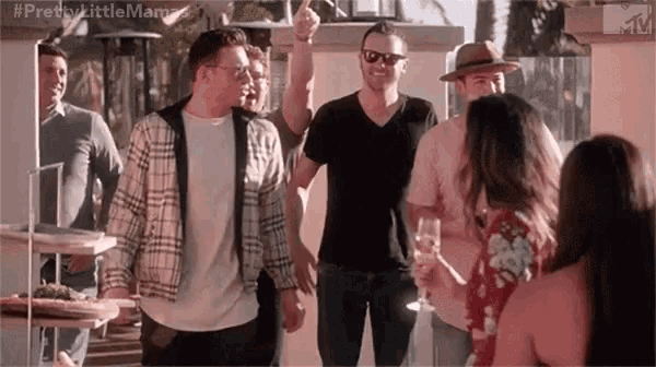 a group of men are standing next to each other at a party with a woman holding a glass of champagne .