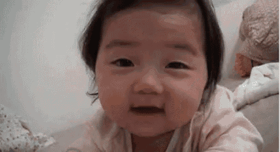 a baby girl is making a funny face and looking at the camera .