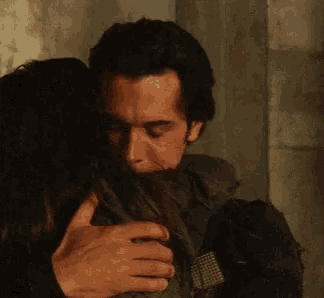 a man and a woman are standing next to each other and the man is holding the woman 's arm .