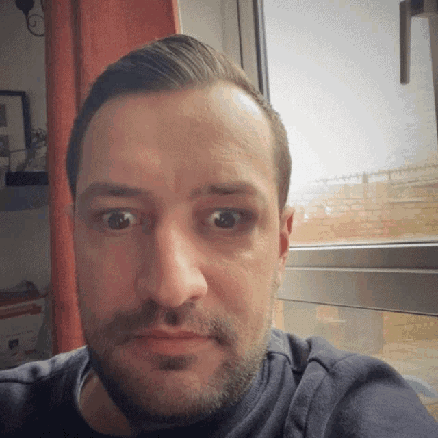 a man with a beard looks at the camera with a serious look on his face
