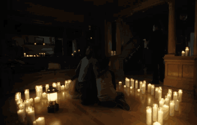 a group of people sitting on the floor with candles around them