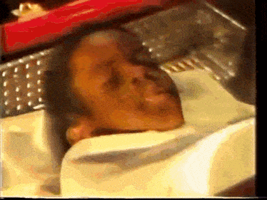a close up of a person laying in a coffin with their eyes closed