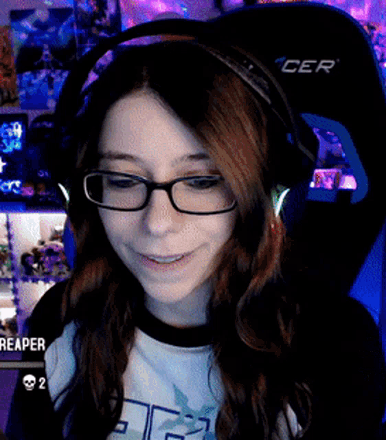 a girl wearing glasses and headphones sitting in a cer chair