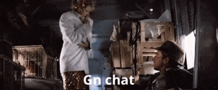 a man and a woman are standing next to each other in a room with the words `` gn chat '' written on it .