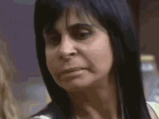 a close up of a woman 's face with a bottle in the background .