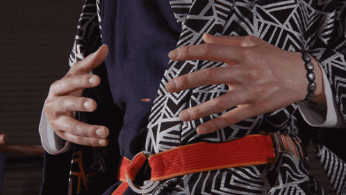 a person wearing a black and white striped shirt has their hands on their stomach