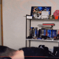 a man laying on a bed in front of a bookshelf