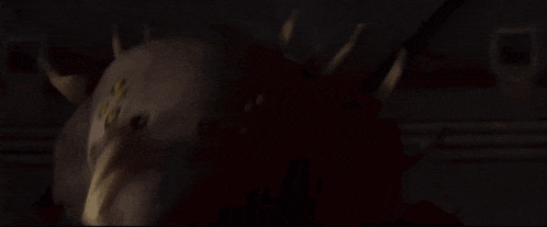a close up of a monster with sharp teeth in the dark .