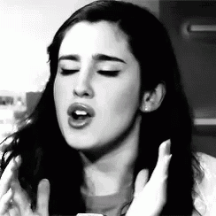 a black and white photo of a woman with her mouth open .