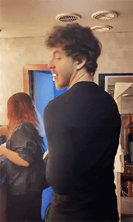 a man in a black shirt is standing in front of a woman